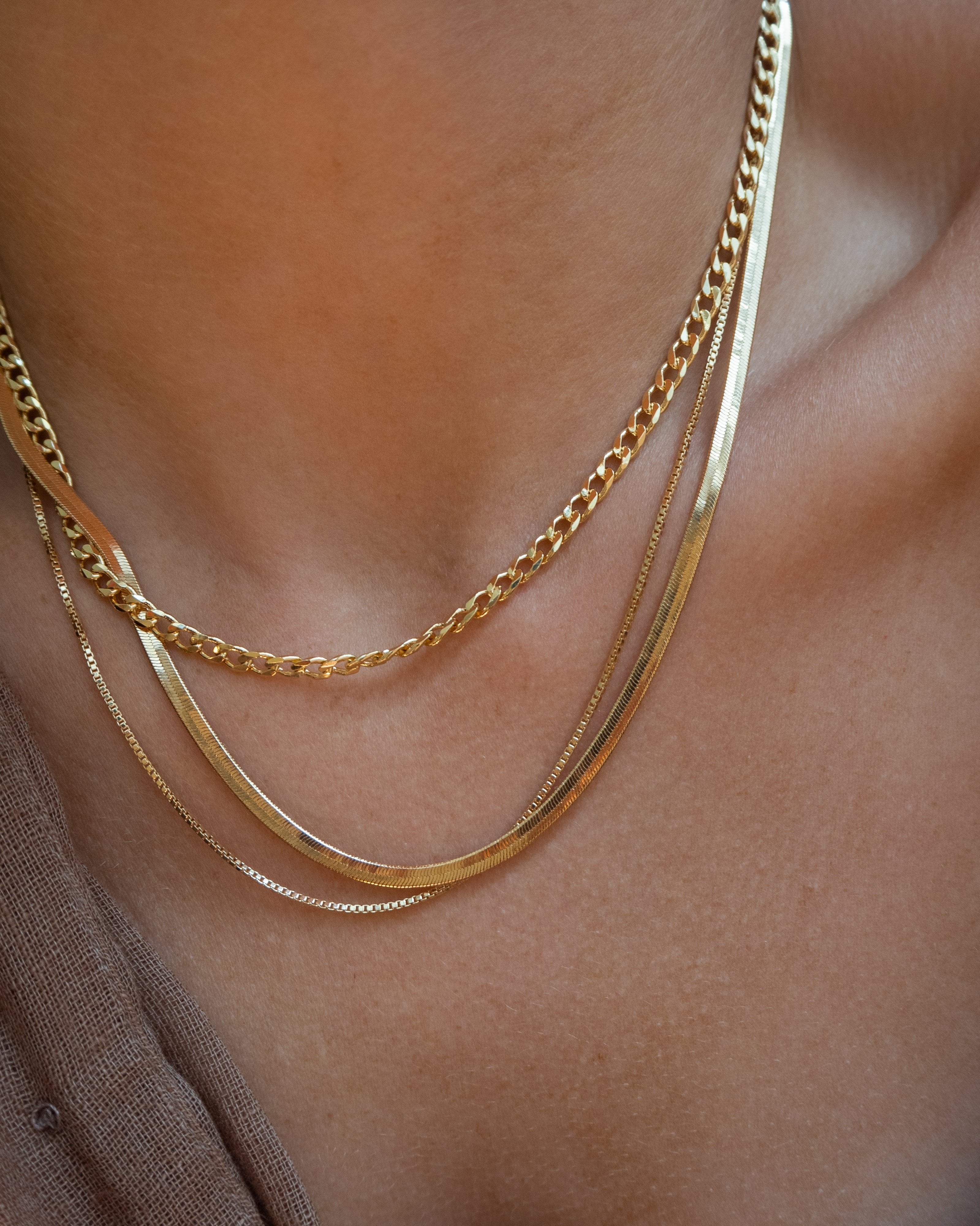 Dainty medium cuban link layering chain in 14k gold filled by Vie en Bleu jewelry.Dainty curb chain, dainty layering chain, 14k, 18k, gold filled chain, gold filled layering chain, mini curb chain, dainty cuban chain, mini curb link necklace, gold filled dainty jewelry, gold filled dainty, dainty necklace, gold layering necklace chain, water resistant, dainty jewelry, dainty necklace