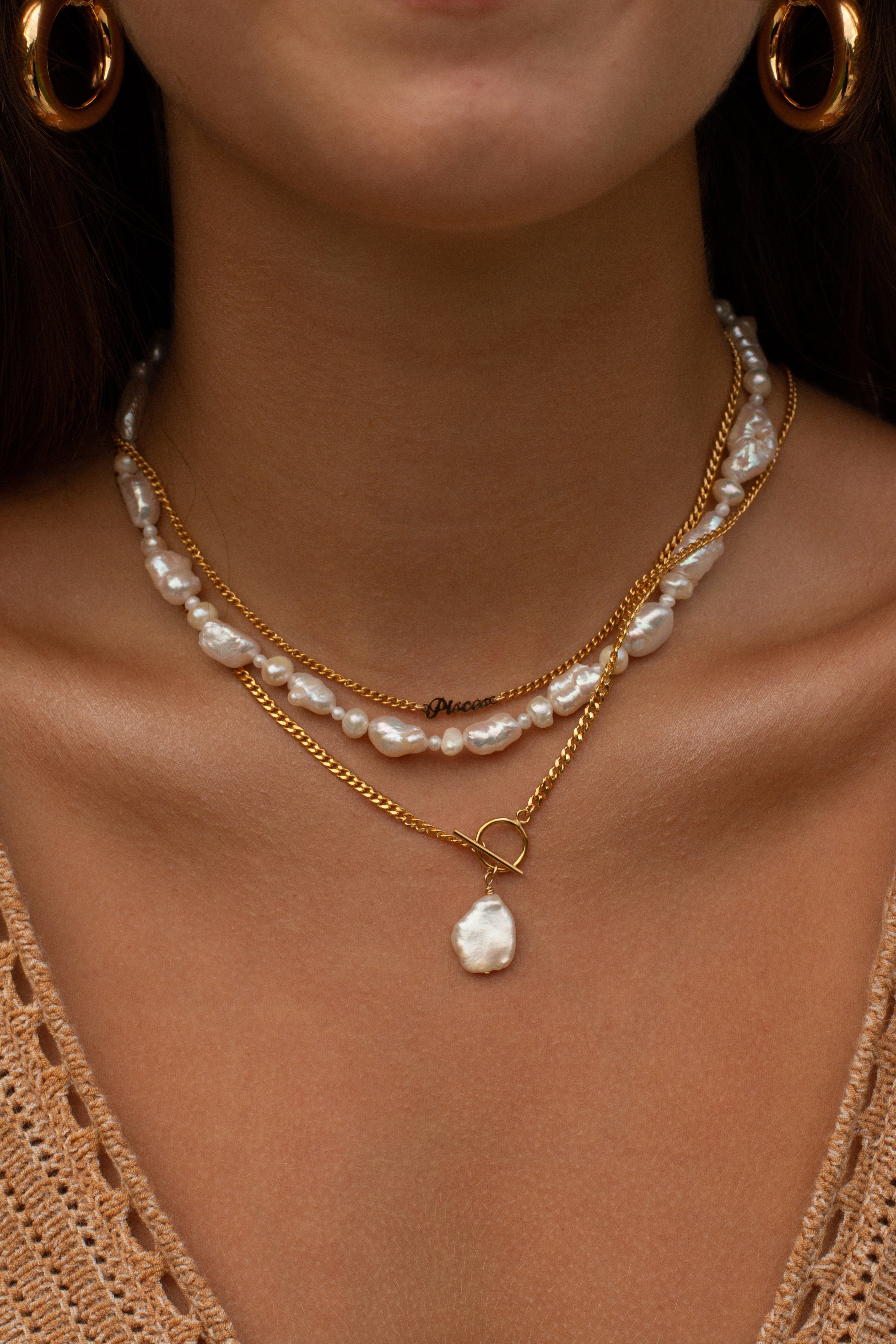 Model wearing pearl necklaces