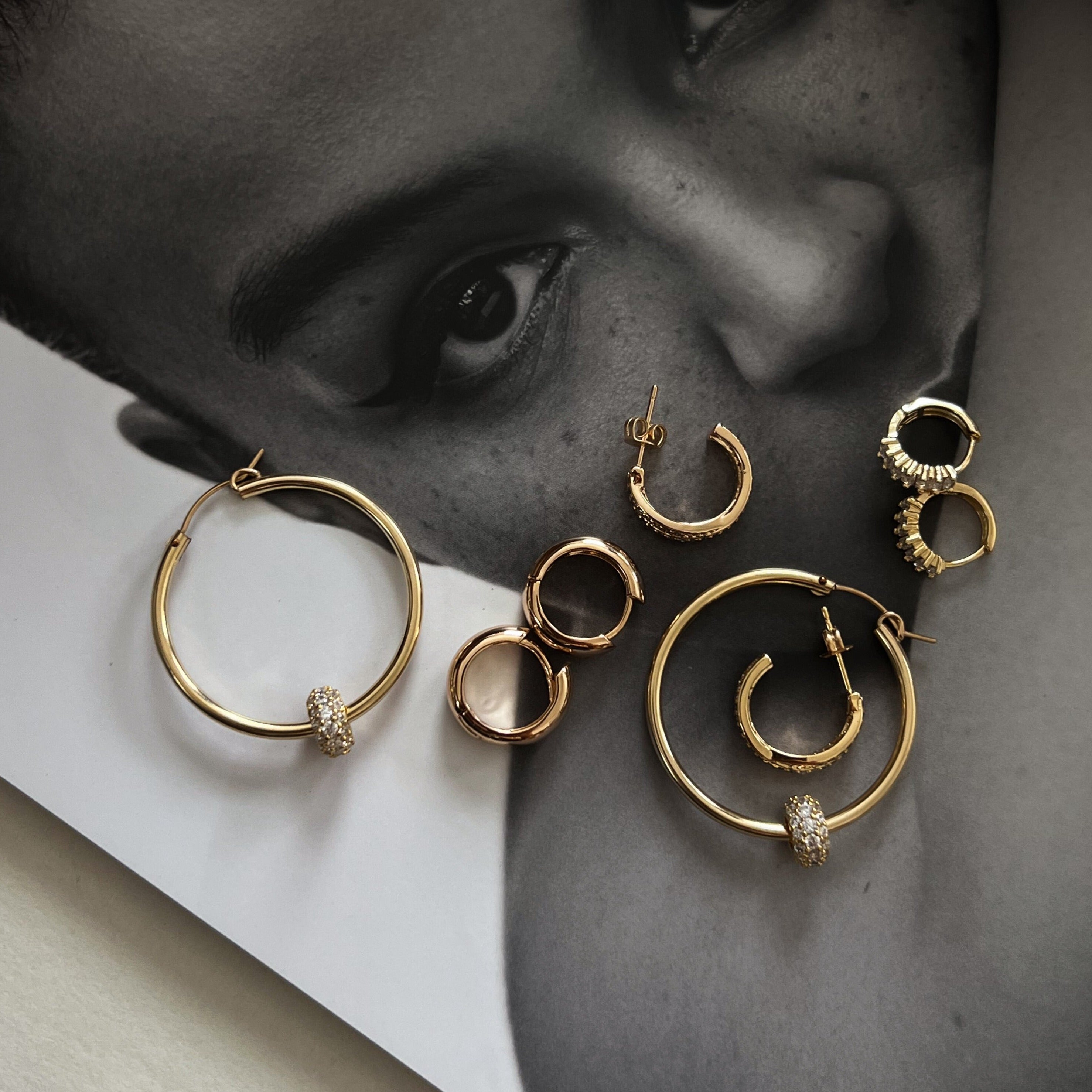 Dainty huggie and hoop earrings in gold. 